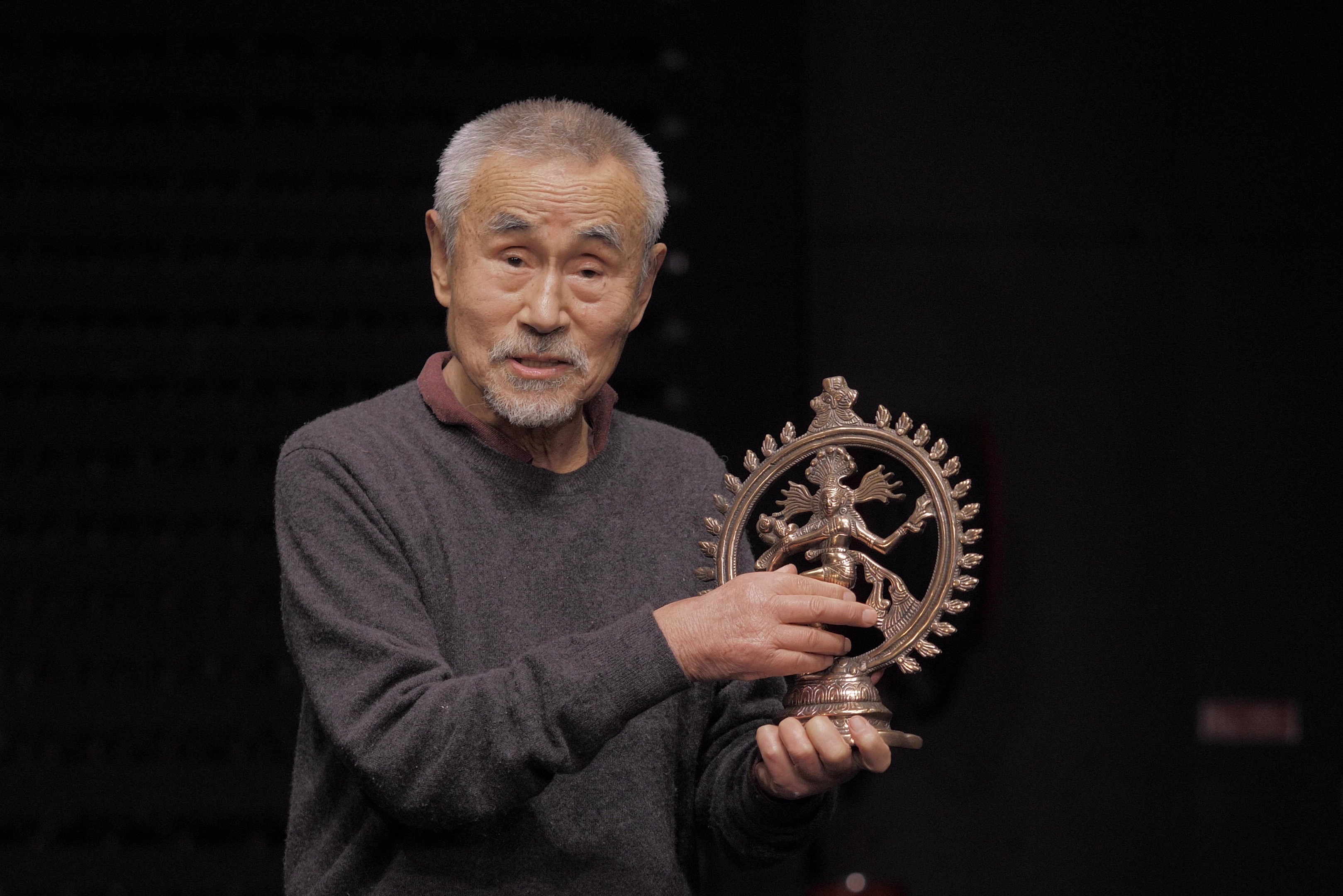 Yoshi Oida montre un objet traditionnel au public.