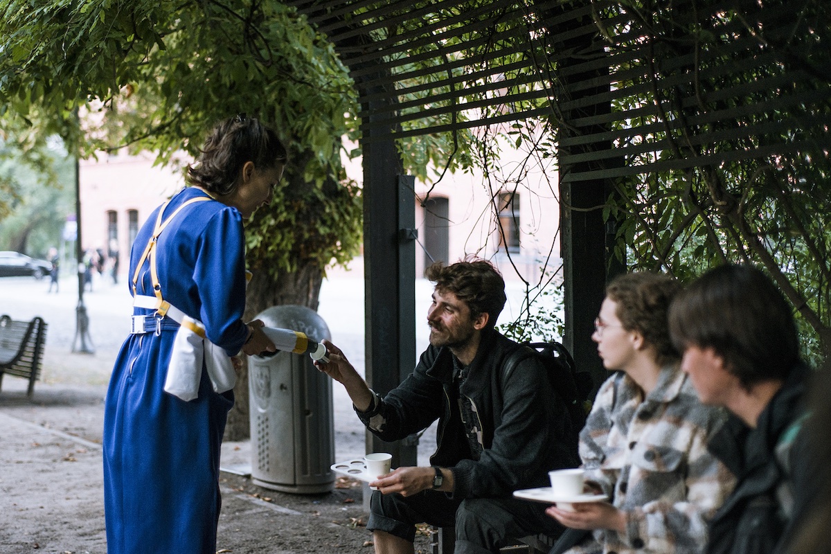 Une personne distribue de l'eau à des personnes assises devant elle