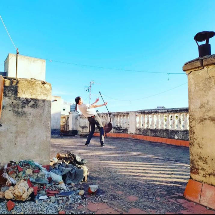 Danseur sur une terrasse ou un pont, au premier plan des débris sur la gauche.